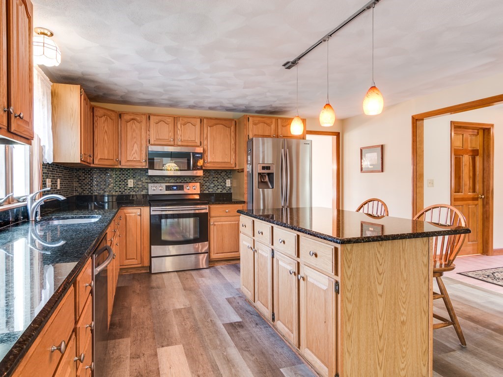 7 Old Town Road Beverly, MA 01915 - Photo 14 of 35 a kitchen with granite countertop a stove top oven a sink dishwasher and a refrigerator with wooden floor