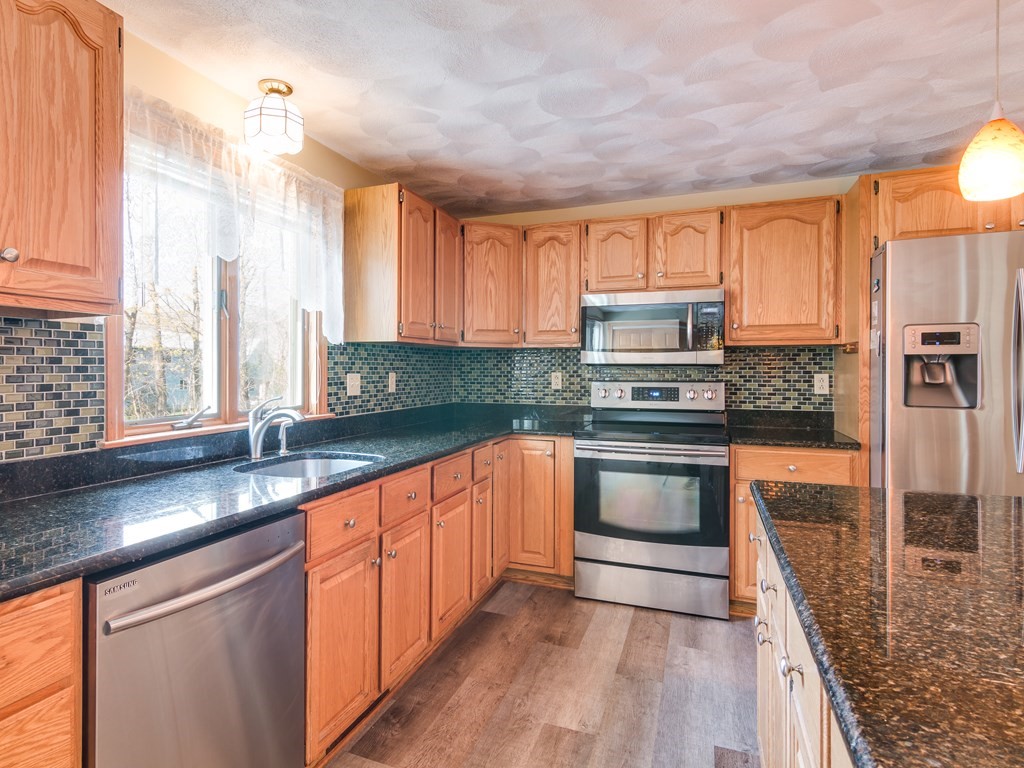 7 Old Town Road Beverly, MA 01915 - Photo 15 of 35 a kitchen with stainless steel appliances granite countertop a stove a sink and a microwave