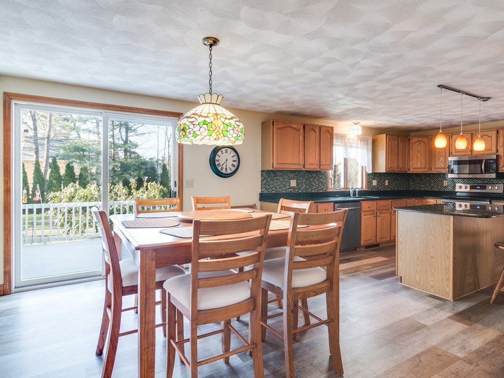 7 Old Town Road Beverly, MA 01915 - Photo 16 of 35 a kitchen with a dining table chairs and white cabinets