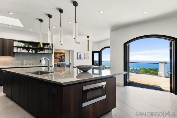 a kitchen with stainless steel appliances granite countertop a table chairs sink and stove top oven