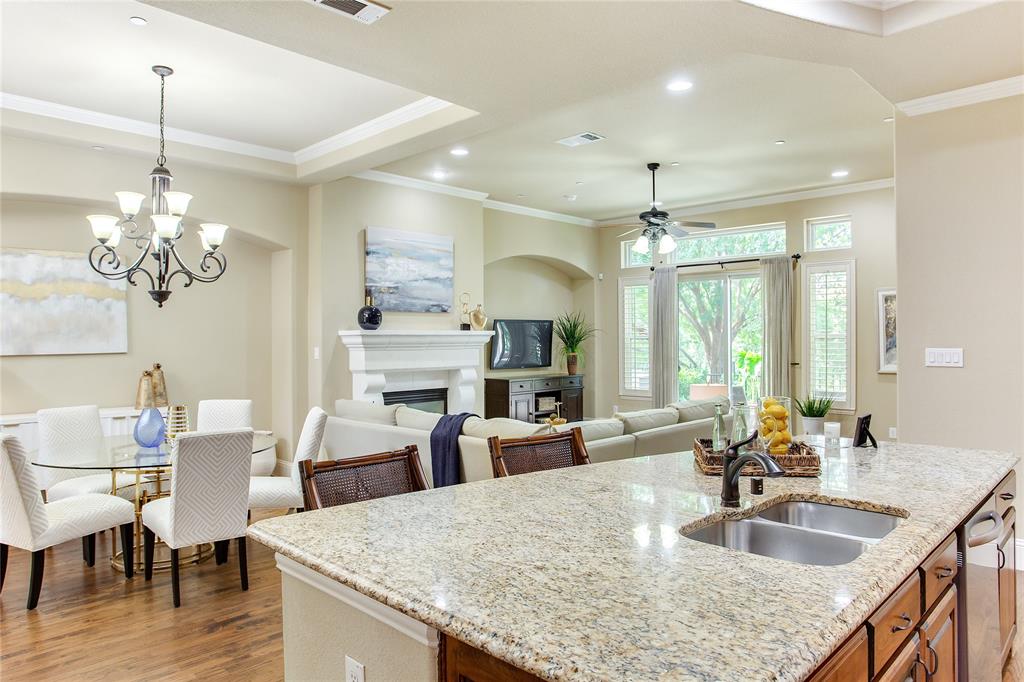 a kitchen with granite countertop a table chairs and wooden floor