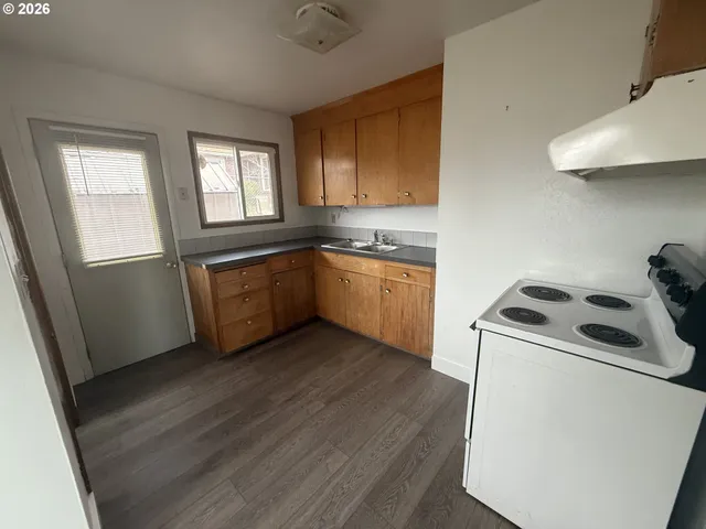 a view of a hallway with wooden floor and entryway