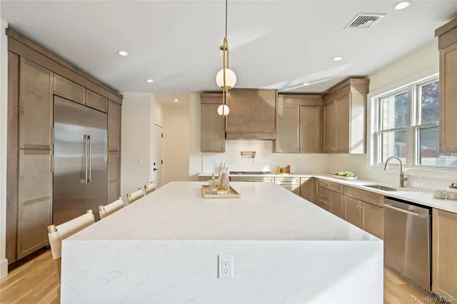 a large kitchen with kitchen island a sink stainless steel appliances and cabinets