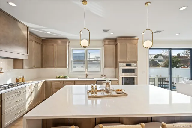 a kitchen with kitchen island granite countertop a sink a stove and a chandelier
