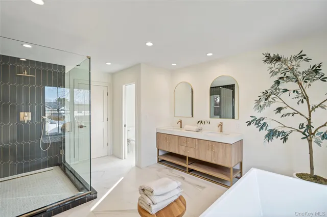 a bathroom with a double vanity sink mirror and bathtub