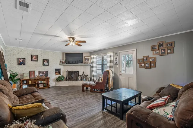 a living room with furniture flat screen tv and a large window