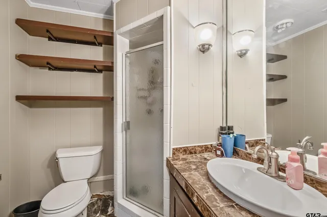a bathroom with a granite countertop toilet sink and shower