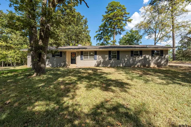 a front view of house with yard and trees around