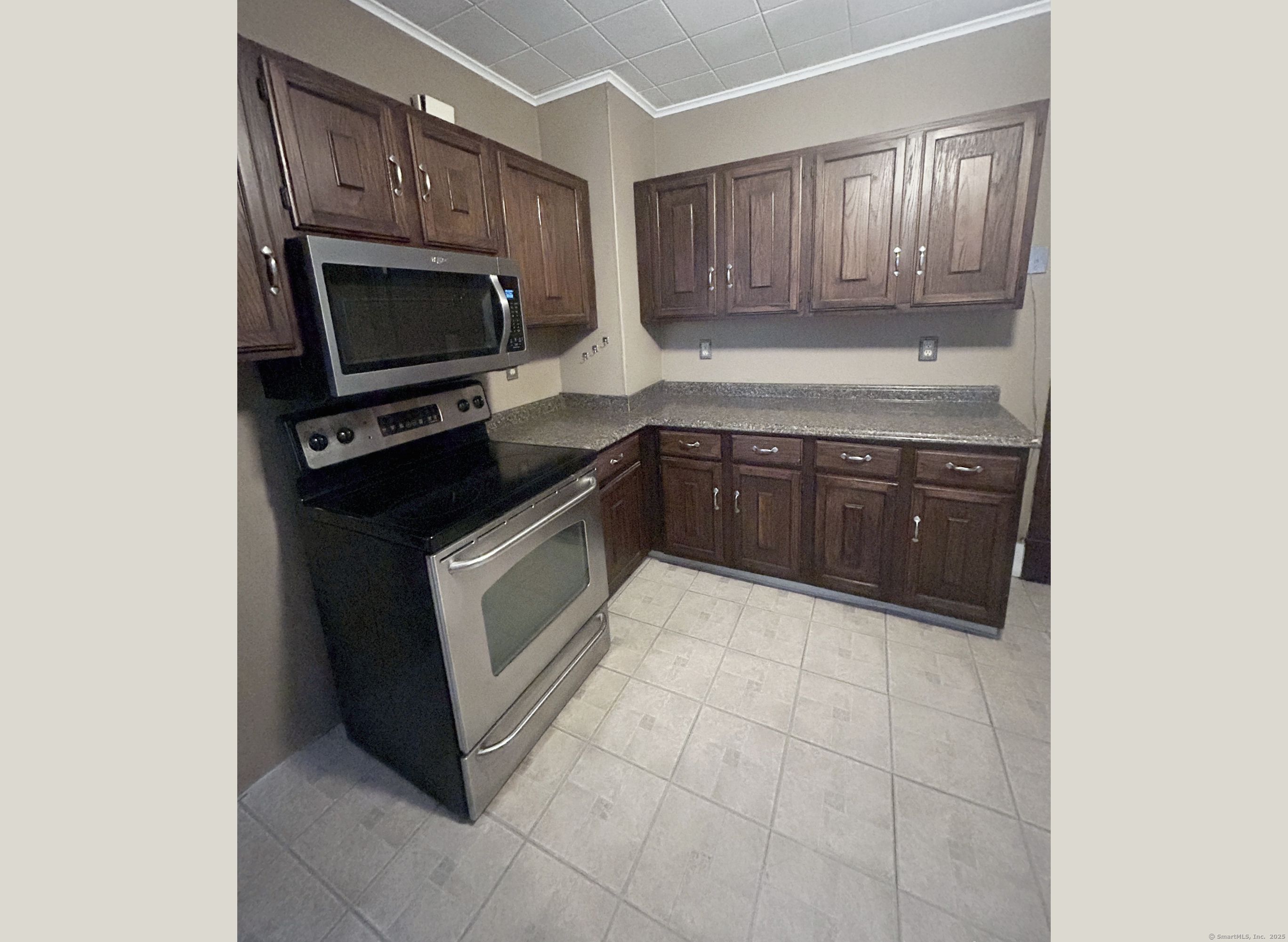 35 Hewey Street Waterbury, CT 06708 - Photo 4 of 14 a kitchen with granite countertop a stove top oven microwave and cabinets