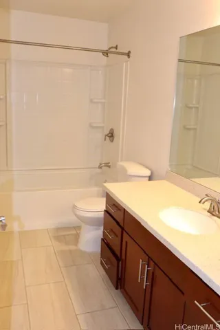 a bathroom with a granite countertop sink a toilet and shower