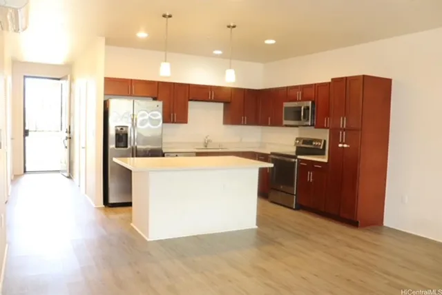 a kitchen with a sink a refrigerator and a stove top oven