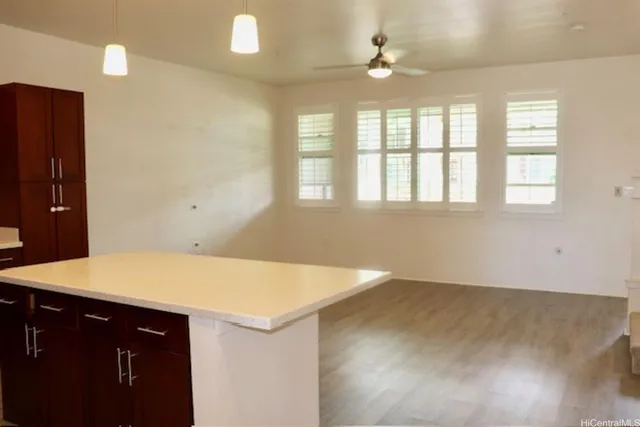 a view of an empty room with windows and chandelier fan