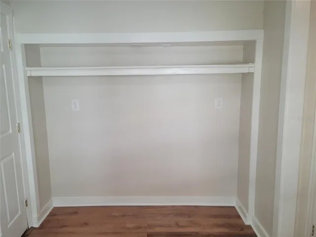 a view of a closet with wooden floor