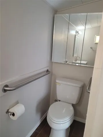 a bathroom with a granite countertop toilet and a mirror