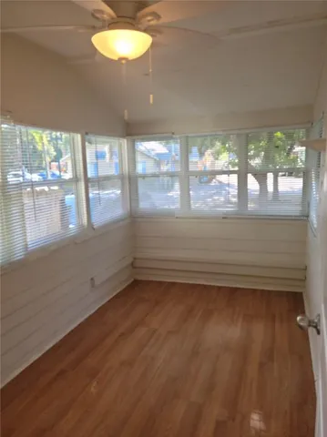 en empty room with wooden floor and windows