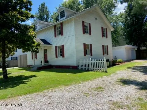 a front view of a house with a yard and trees