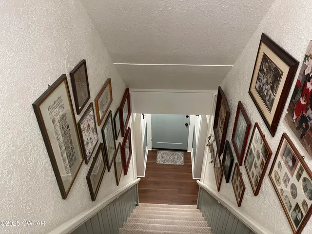 a view of a hallway with wooden floor and stairs