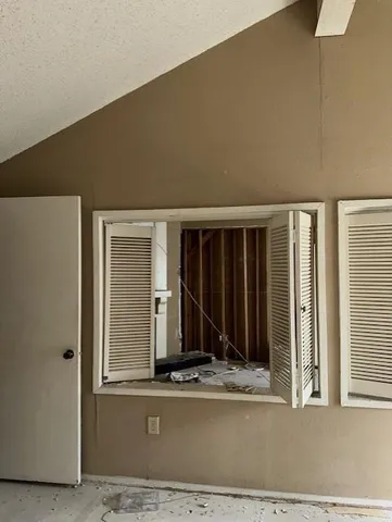 a view of a bedroom with wooden floor and a window