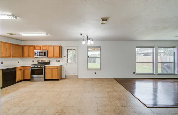 a view of a livingroom with wooden floor and a ceiling fan
