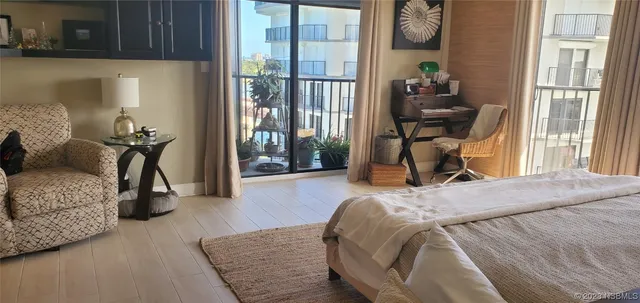 a bedroom with a bed and large windows