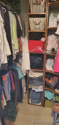 a view of walk in closet with clothes and shoes