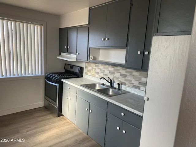 a kitchen with a sink stove and cabinets