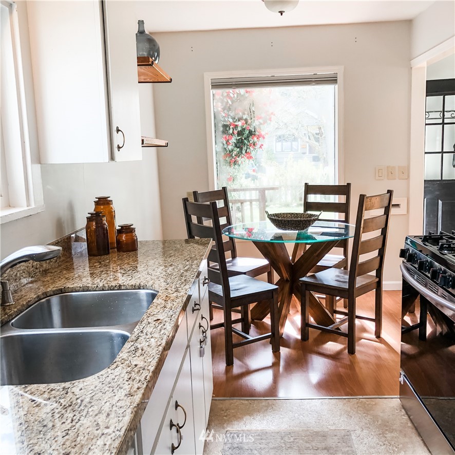 528 North 74th Street Seattle, WA 98103 - Photo 13 of 34 a kitchen with a stove a sink and cabinetry