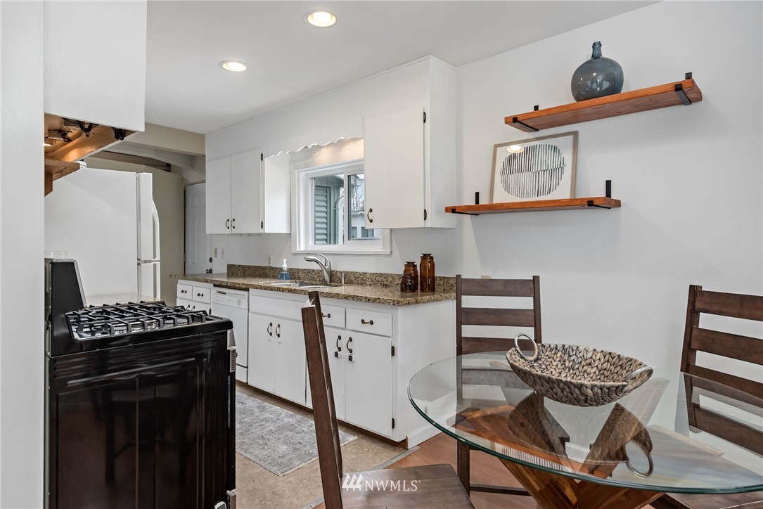 528 North 74th Street Seattle, WA 98103 - Photo 14 of 34 a kitchen with stainless steel appliances a stove a sink and cabinets