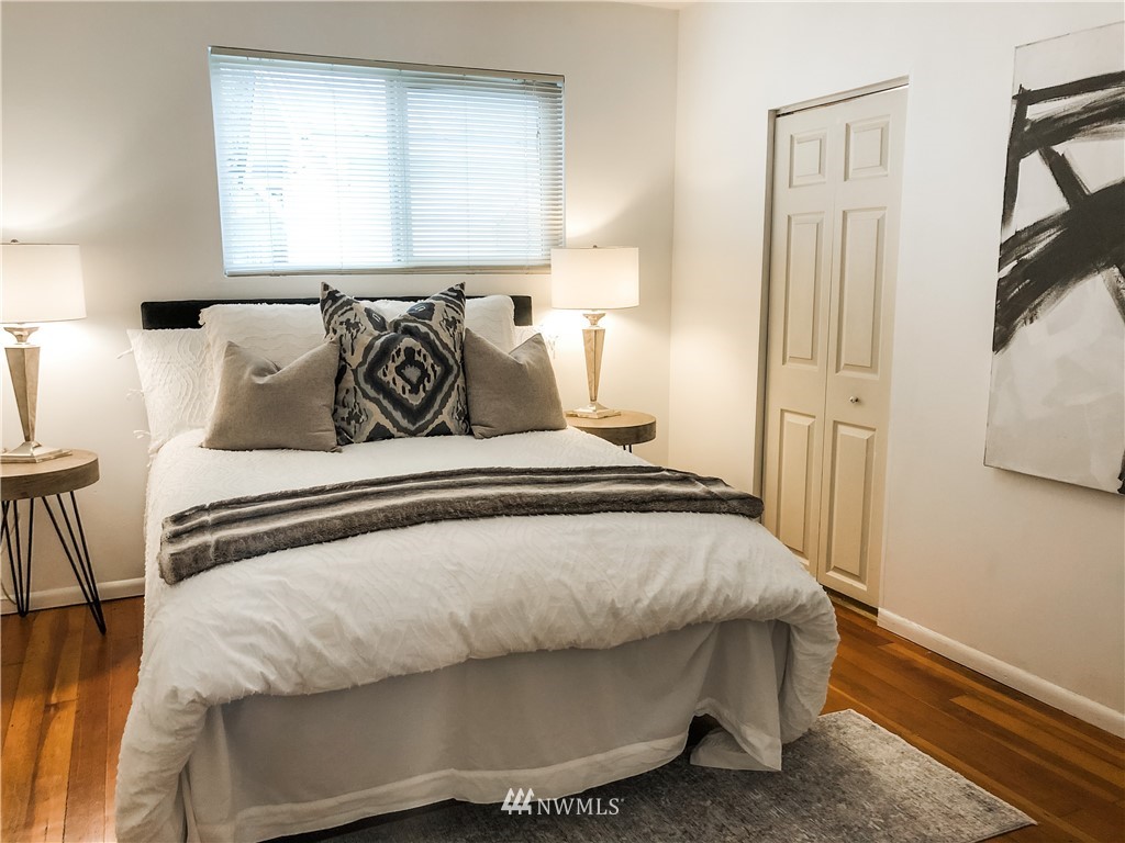 528 North 74th Street Seattle, WA 98103 - Photo 18 of 34 a bedroom with a bed and wooden floor