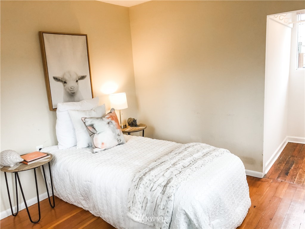528 North 74th Street Seattle, WA 98103 - Photo 20 of 34 a bedroom with a bed and wooden floor