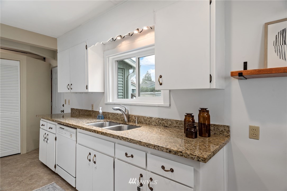 528 North 74th Street Seattle, WA 98103 - Photo 22 of 34 a kitchen with granite countertop a sink and cabinets