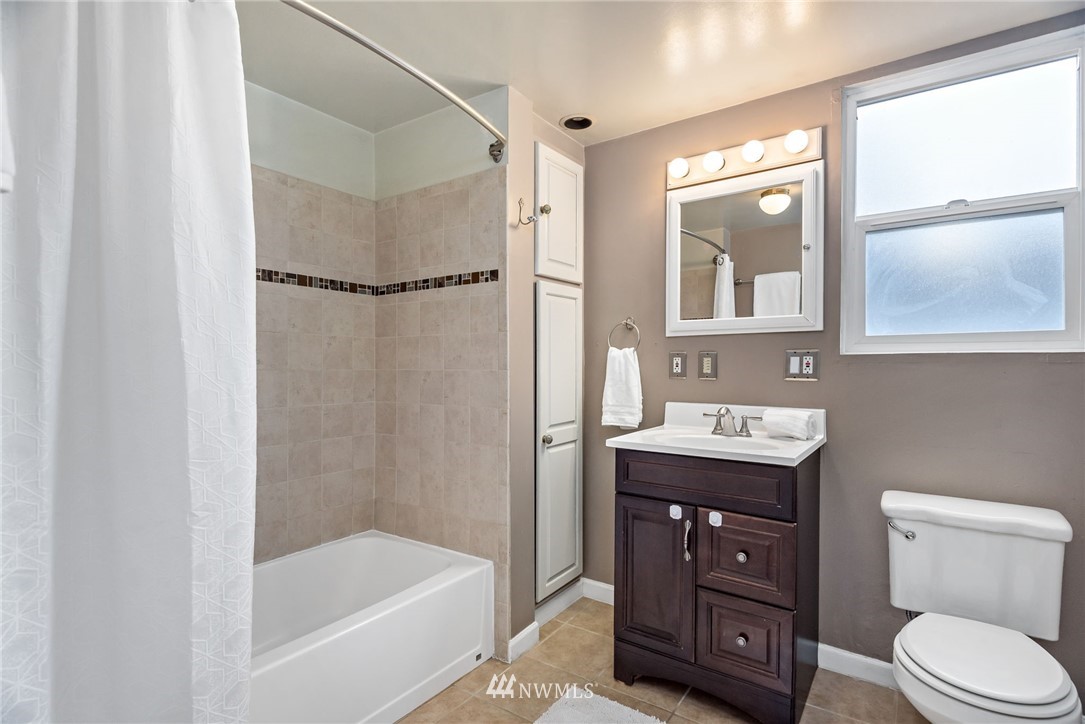 528 North 74th Street Seattle, WA 98103 - Photo 27 of 34 a bathroom with a sink a toilet and shower