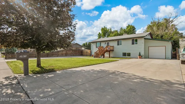 a view of a house with backyard and a tree