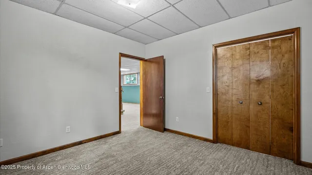 a view of an empty room with closet and a window