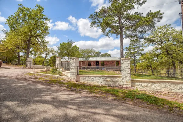 a view of a house with a big yard and large trees