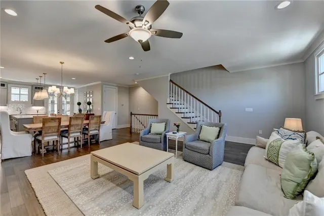 a living room with furniture a table and kitchen view