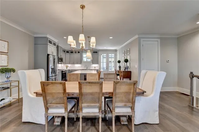 a view of a dining room with furniture a chandelier and wooden floor