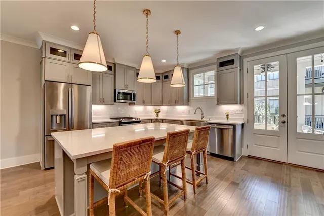 a kitchen with stainless steel appliances granite countertop a stove a refrigerator a kitchen island a sink and a refrigerator