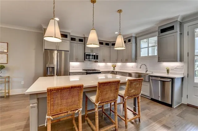 a kitchen with kitchen island granite countertop a sink a center island and stainless steel appliances