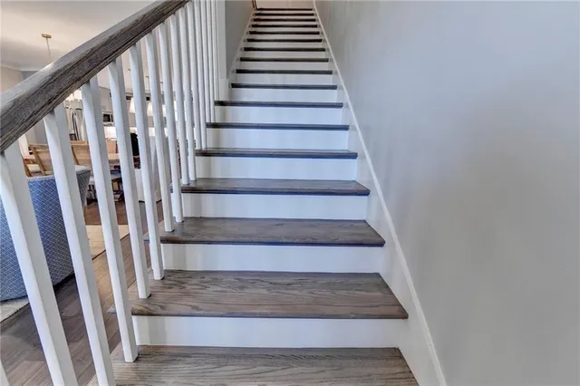 a view of staircase with wooden floor and white walls