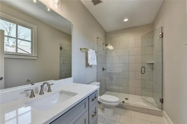 a bathroom with a sink a toilet and shower