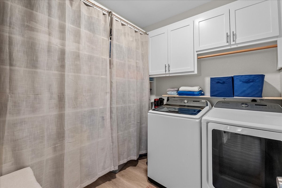 130 Beachcomber Avenue Surfside Beach, TX 77541 - Photo 5 of 33 This laundry room features modern appliances with a sleek design, ample white cabinetry for storage, and a convenient hanging rod. A curtain provides an elegant touch, offering separation for storage.