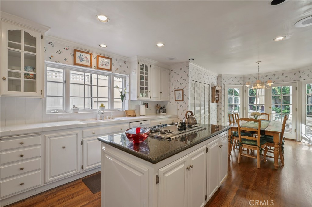 14015 Roblar Road Sherman Oaks, CA 91423 - Photo 10 of 35 a kitchen with granite countertop sink stove and white cabinets with wooden floor
