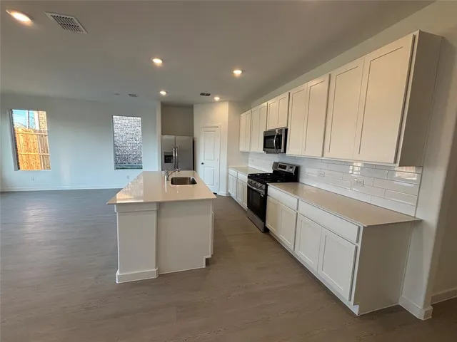 a kitchen with counter top space cabinets and stainless steel appliances