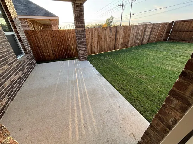 a view of a backyard with wooden fence