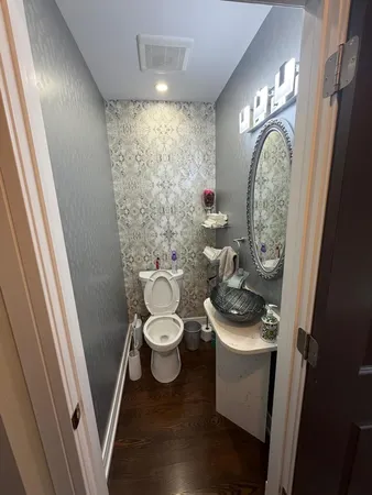 a bathroom with a toilet a sink and a mirror
