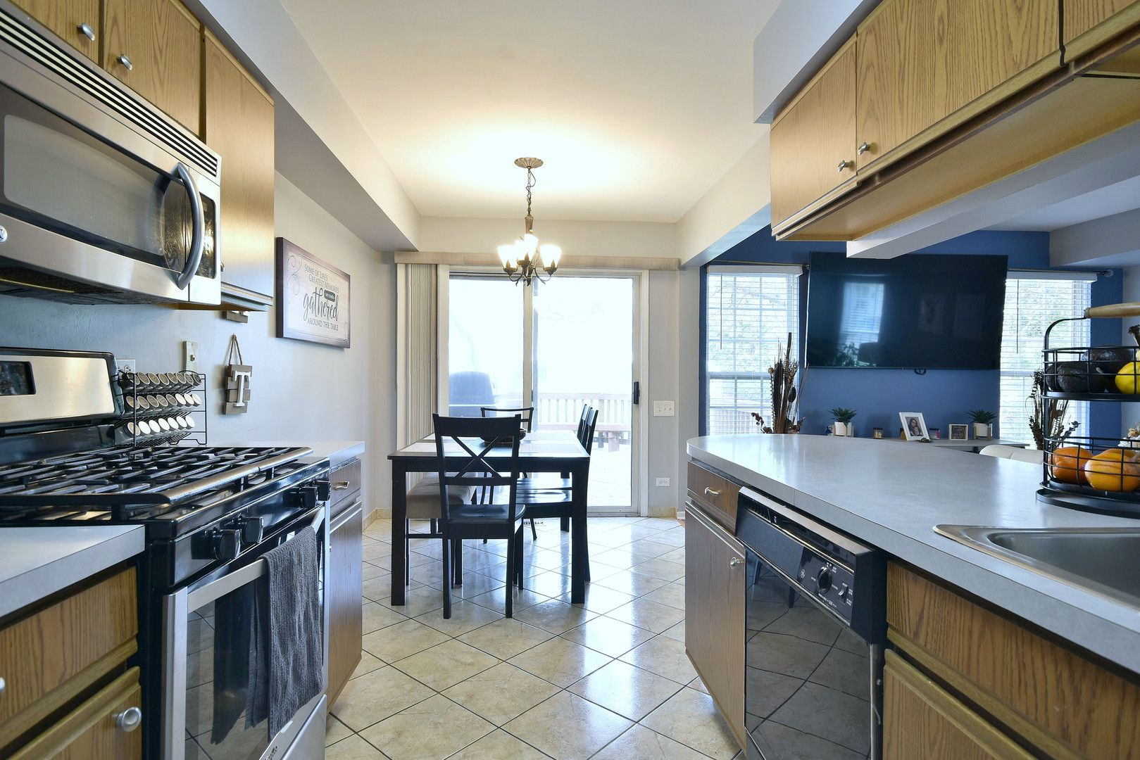 210 Shadybrook Lane Aurora, IL 60504 - Photo 12 of 26 a kitchen with stainless steel appliances a stove a sink a dining table and chairs with wooden floor