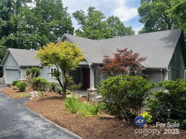 front view of a house with a yard and potted plants