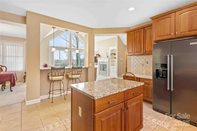 a kitchen with stainless steel appliances granite countertop a refrigerator and a stove top oven