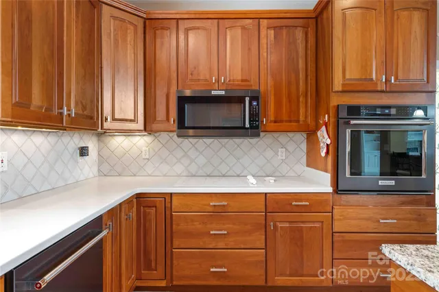 a kitchen with granite countertop cabinets and black appliances